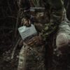 a person in camouflage holding a book