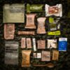 HALF_DAY_MENU_III a group of packages on a camouflage surface