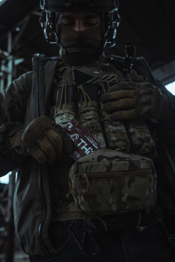 a person in military gear holding a pack of food